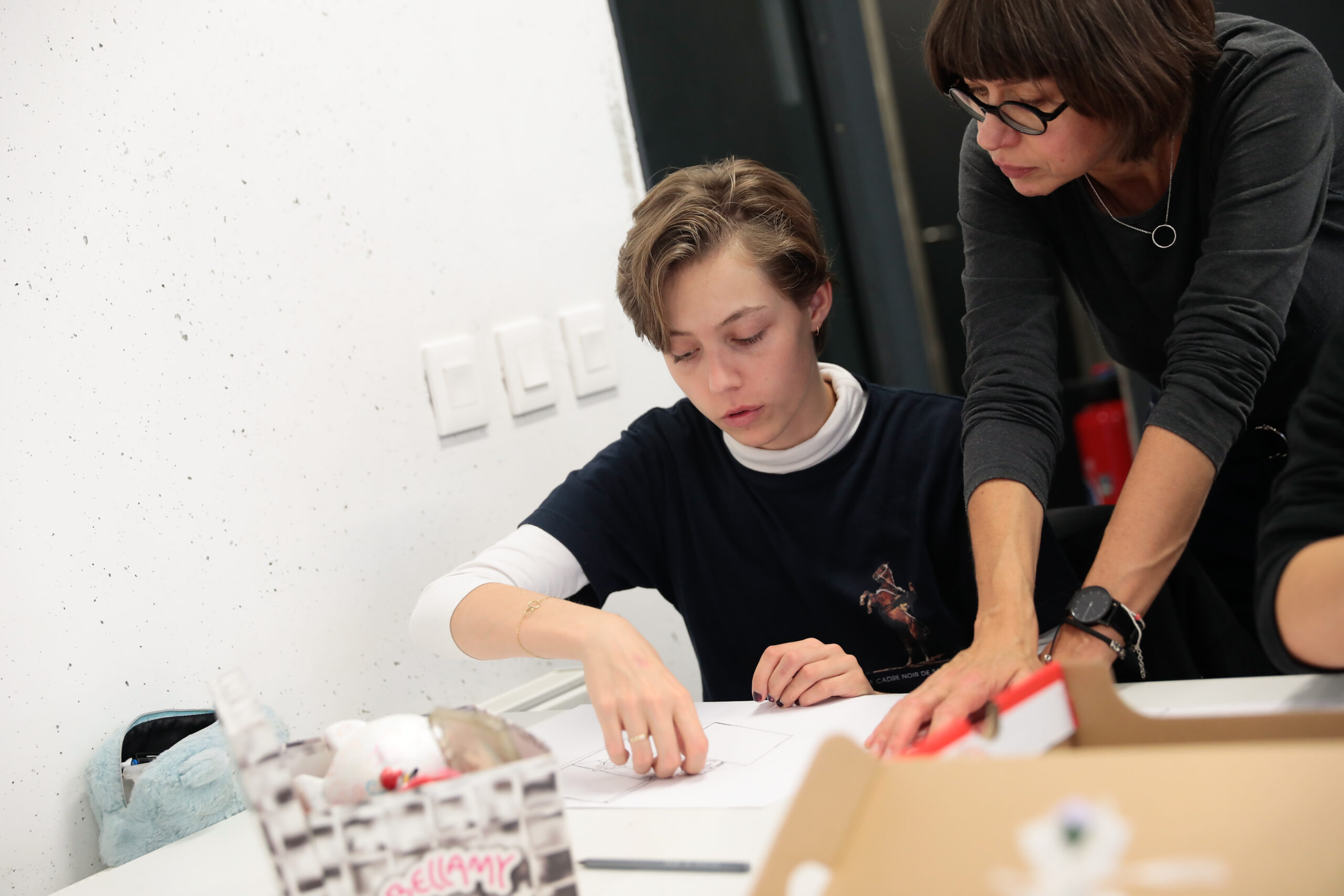 Teacher accompanying a student during class work at ESMA