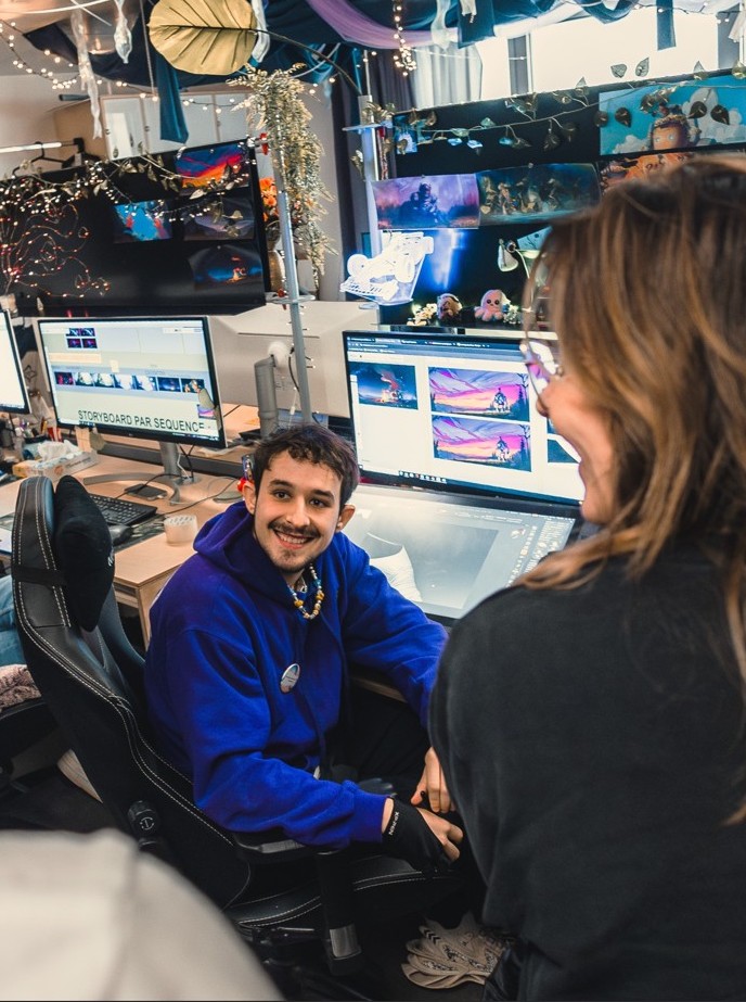 Students working as a team in a design room at ESMA, surrounded by screens and digital storyboards.