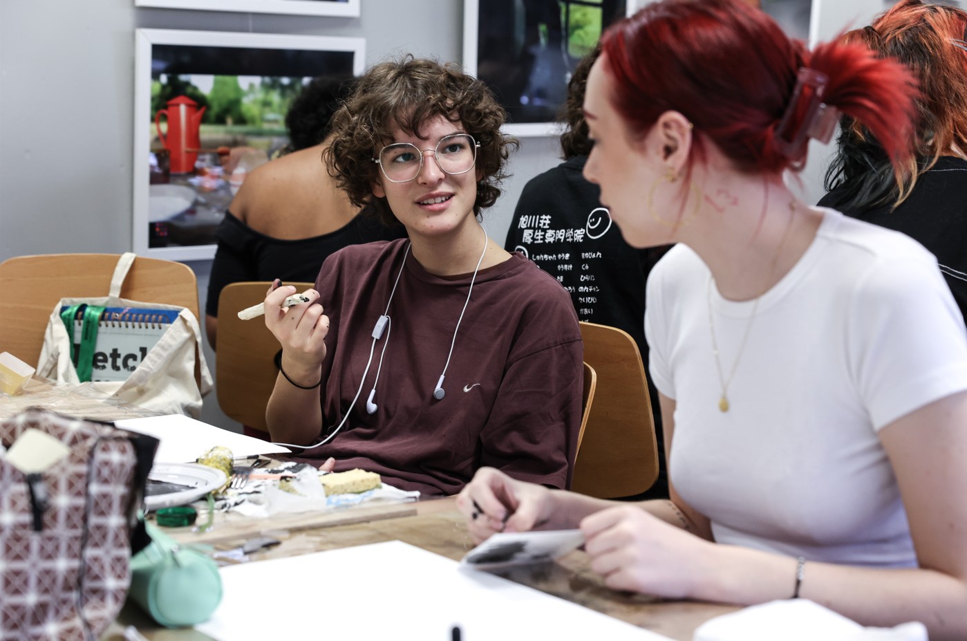 Deux étudiantes discutant ensemble autour d’une table de travail.