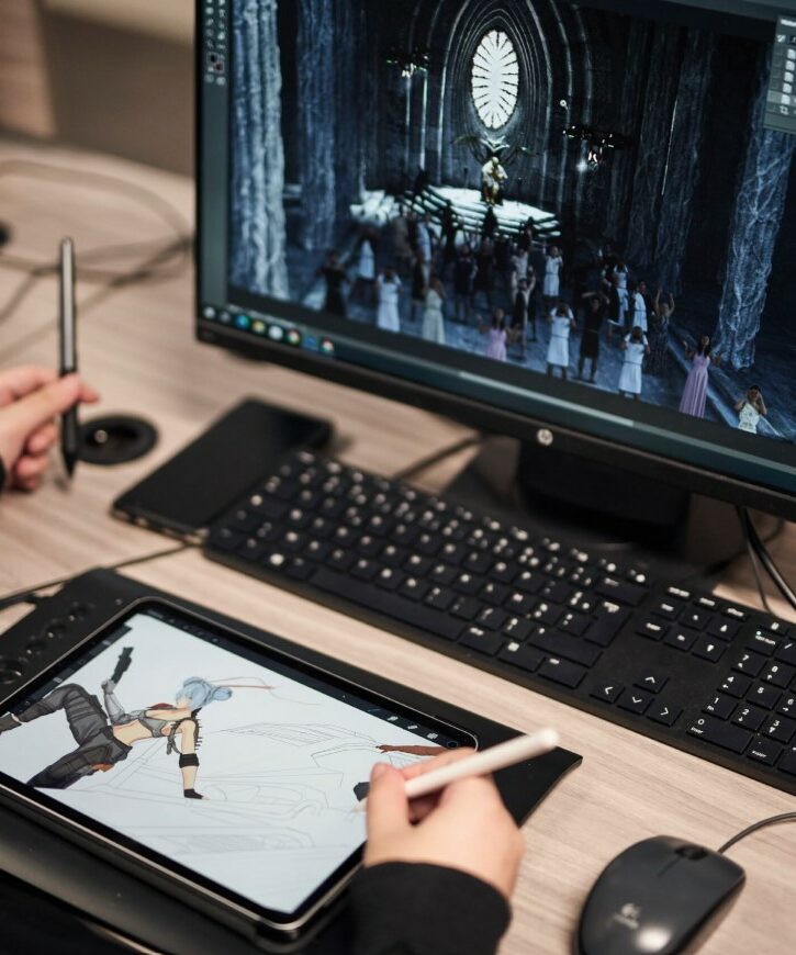 Étudiant travaillant sur un projet de jeu vidéo avec tablette graphique et logiciels spécialisés.