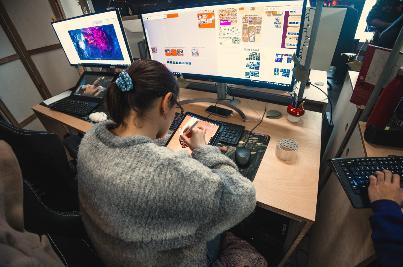 Étudiante travaillant sur tablette graphique devant un double écran.