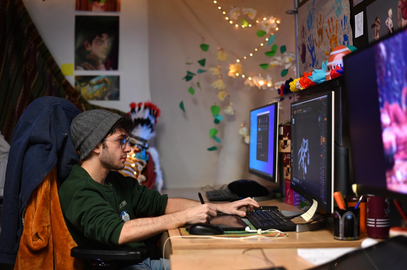 Graphic design student on dual screen with tablet.